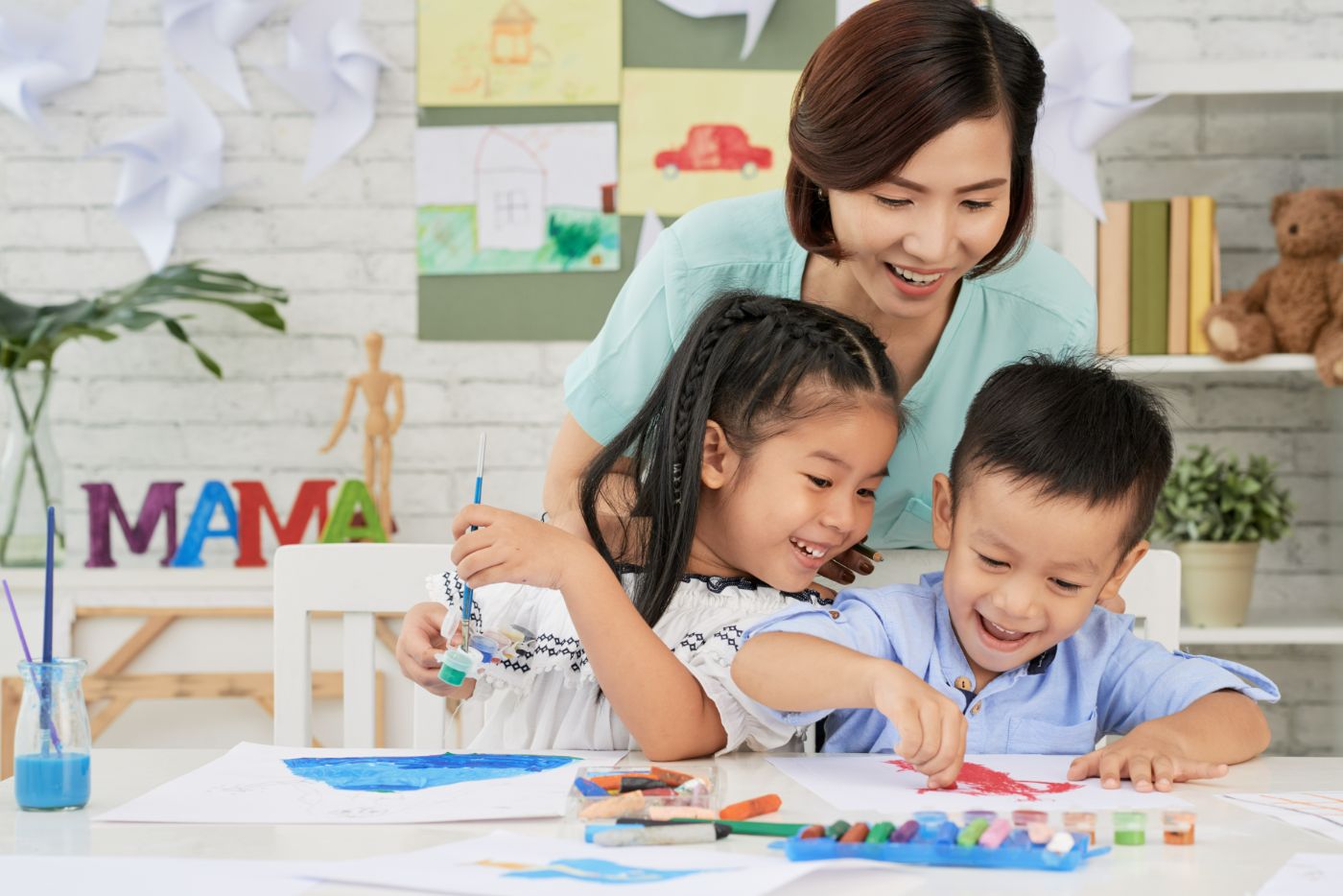 Cheerful children and teacher drawing
